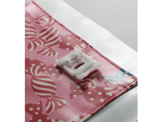 Brother sewing machine presser foot on pink patterned fabric with decorative stitching