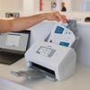 Hand inserting document into Brother ADS-4900W wireless desktop scanner with touchscreen