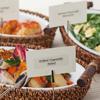 Brother laminated label on food card in wicker basket with grilled vegetables and salad