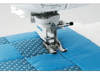 Brother sewing machine presser foot stitching blue quilted fabric with decorative pattern
