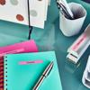 Brother label maker on desk with turquoise notebook, pens, and organized supplies