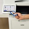 Hand scanning ID badge on Brother MFC-L9610CDN color laser all-in-one printer with touchscreen