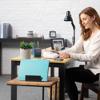 Woman organizing workspace with Brother P-touch portable label maker on home office desk