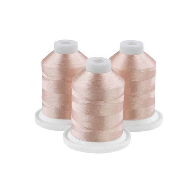 Three peach-colored embroidery thread spools on white bases