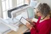 Woman using Brother Luminaire Innov-ís XP3 sewing and embroidery machine with touchscreen display